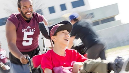 Mt. SAC Student-Athlete lending a helping hand at the 2018 Mt. SAC Disability Athletics Fair